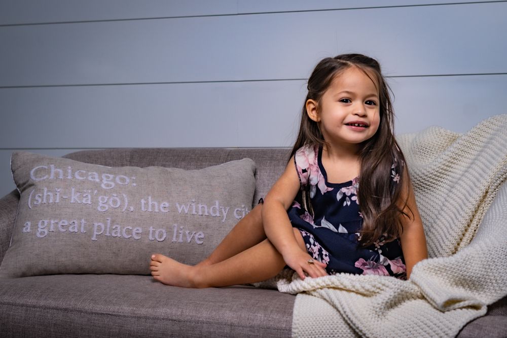 A cozy reading session with matching navy floral dresses against a white backdrop.