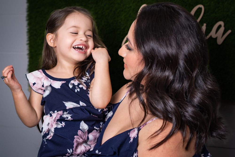 Two people share joyful laughter while sitting together on a couch.