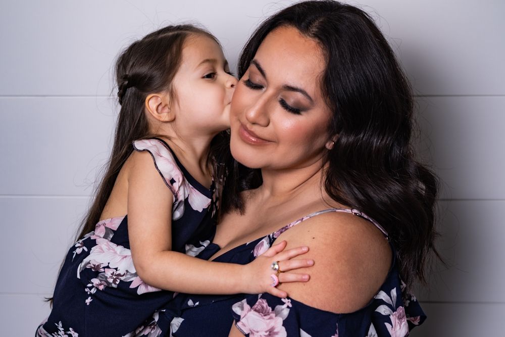 Tender bonding moment between two people wearing coordinated navy floral outfits.