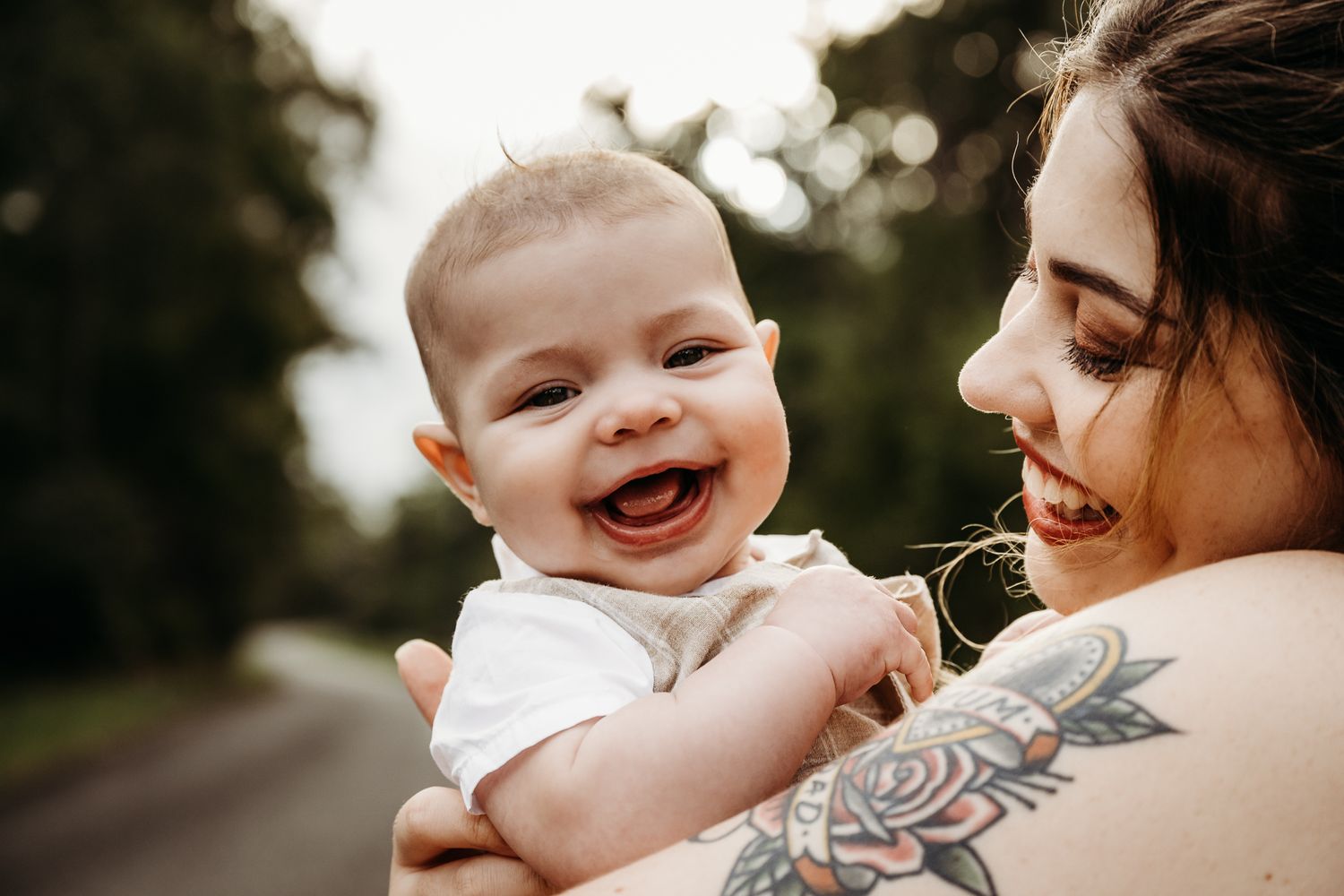 Joyful moment between parent and baby outdoors on a sunny day.