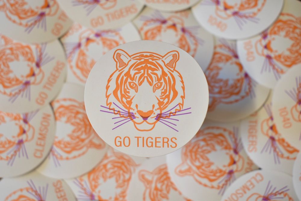 Close-up of circular stickers featuring orange tiger face design with 'Go Tigers' text.