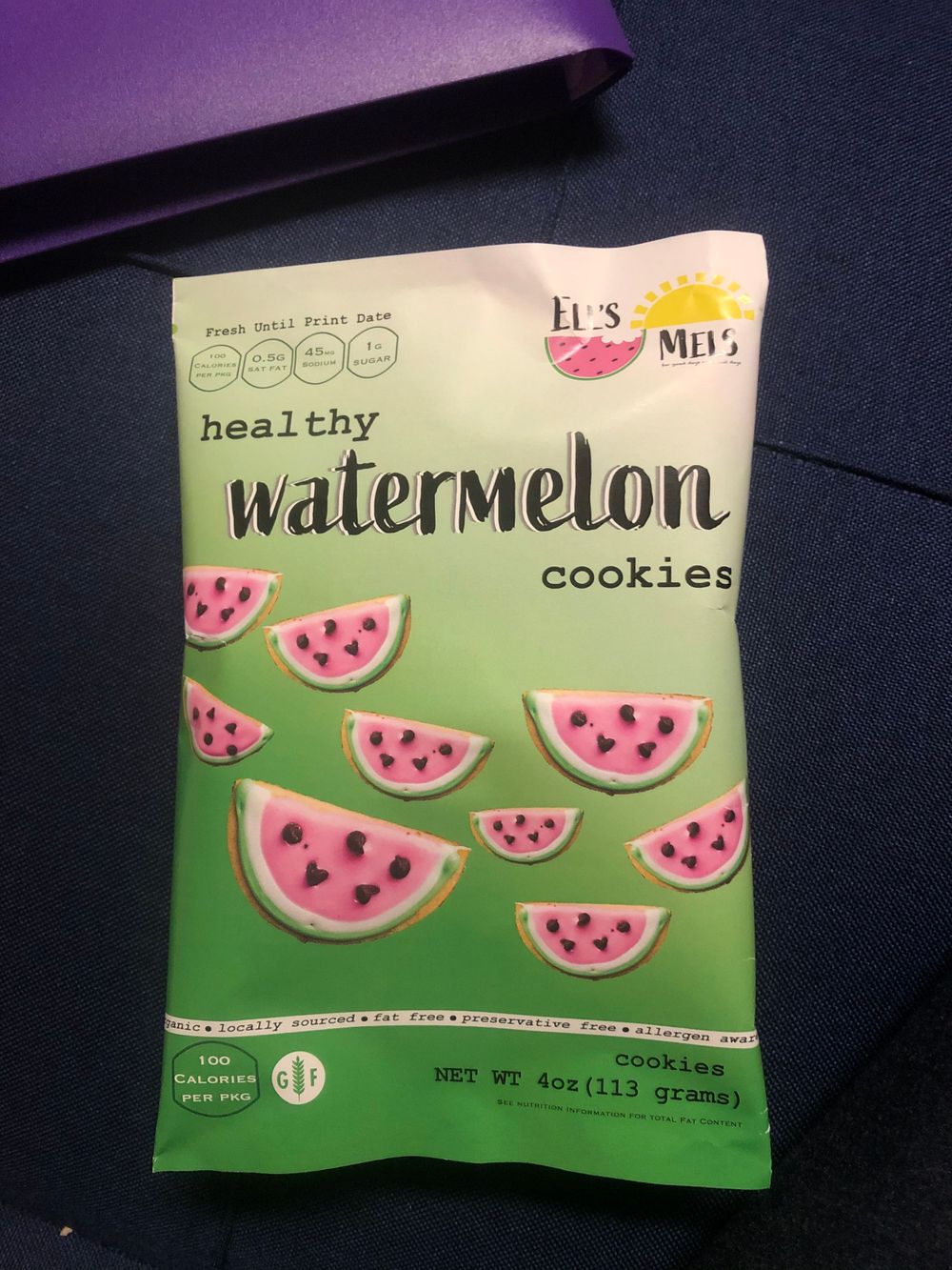Package of healthy watermelon cookies with illustrated watermelon slices on green background.