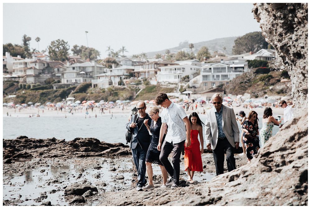 guests walking to elopement, wedding guests on beach