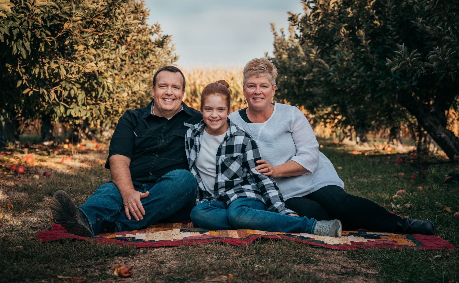 family sitting on blanket