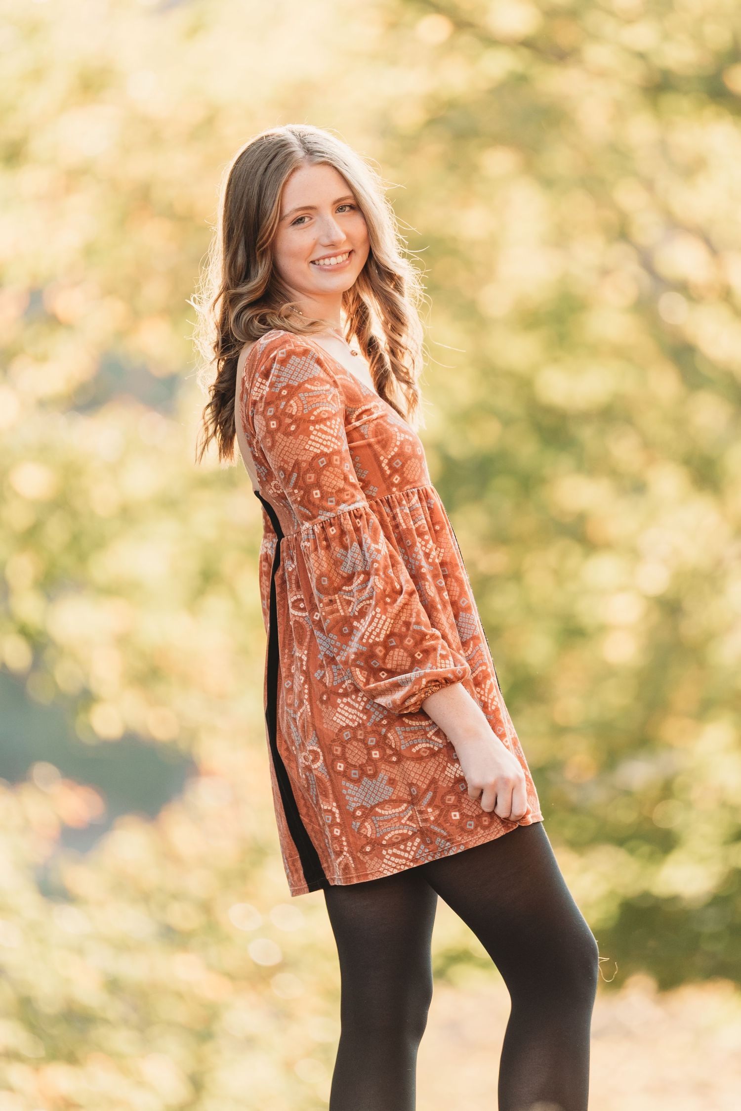 Autumn outdoor portrait session with warm golden lighting and natural backdrop.