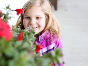 Little girl peeking over flowers
