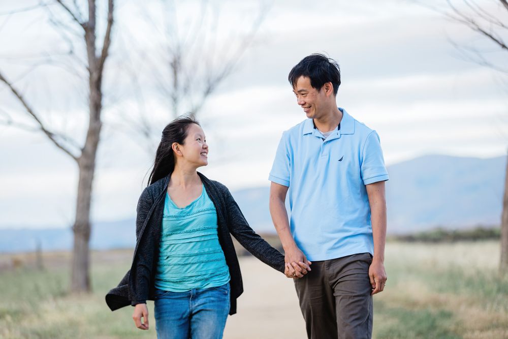 Couple walking together on a scenic trail surrounded by nature.
