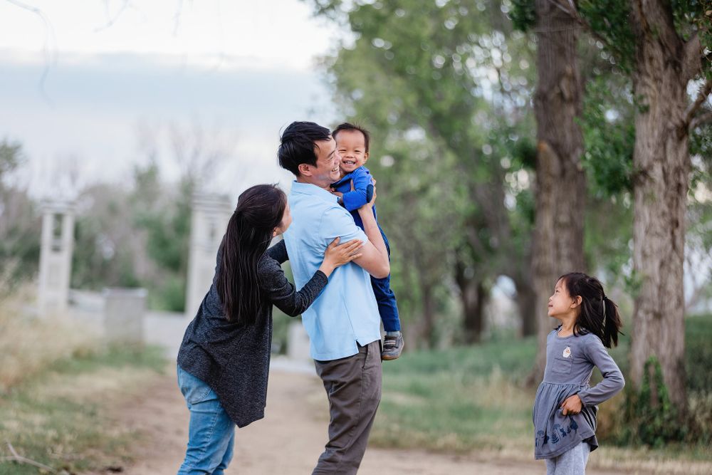 Family sharing joyful moments together on a nature path with trees.