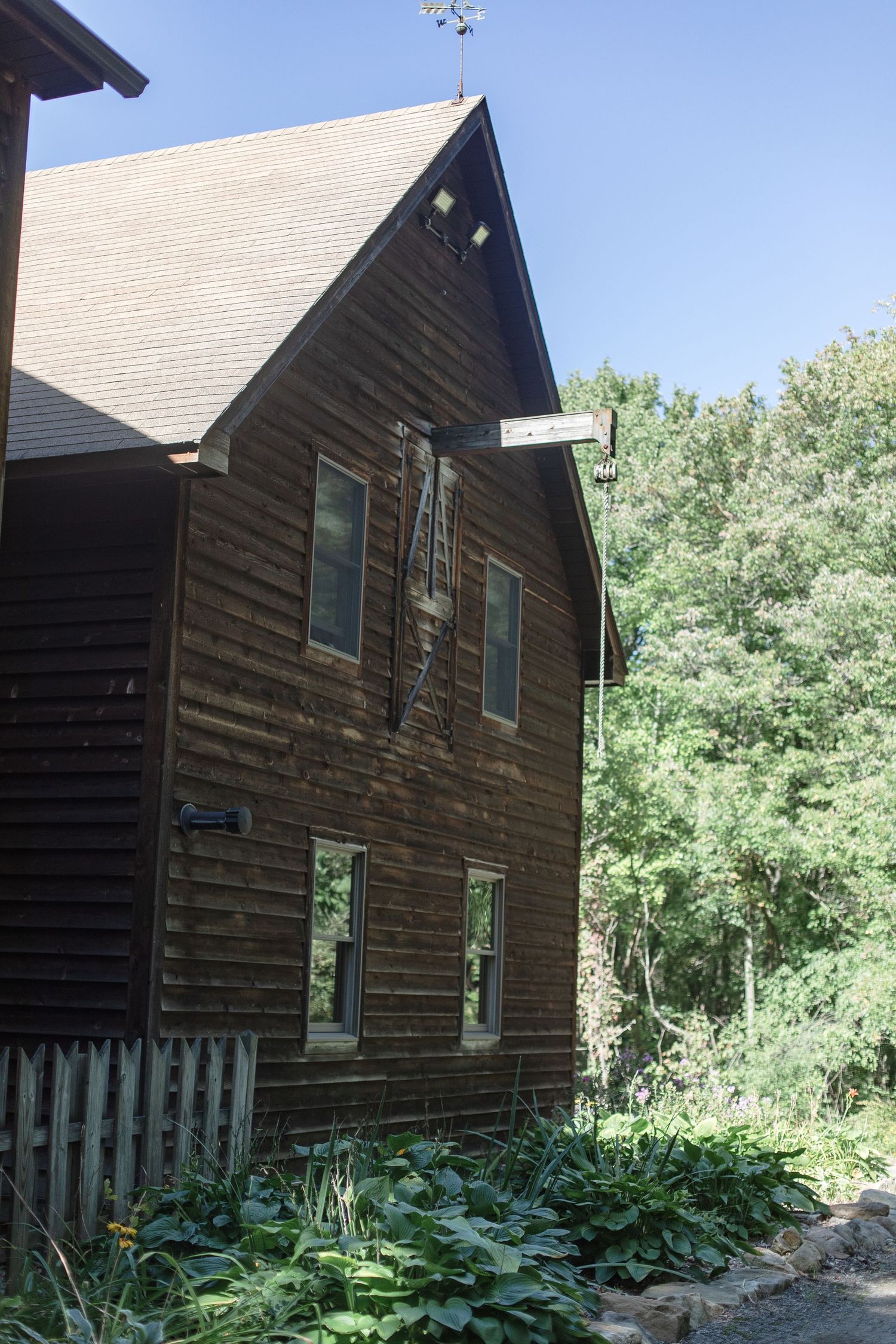 Rustic wooden cabin exterior with green landscaping and natural surroundings.