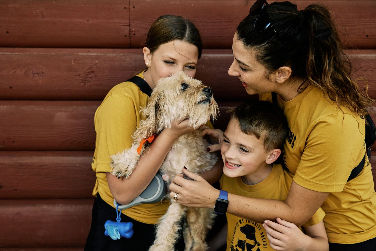 Candid family moments captured against rustic wooden background wearing yellow shirts.