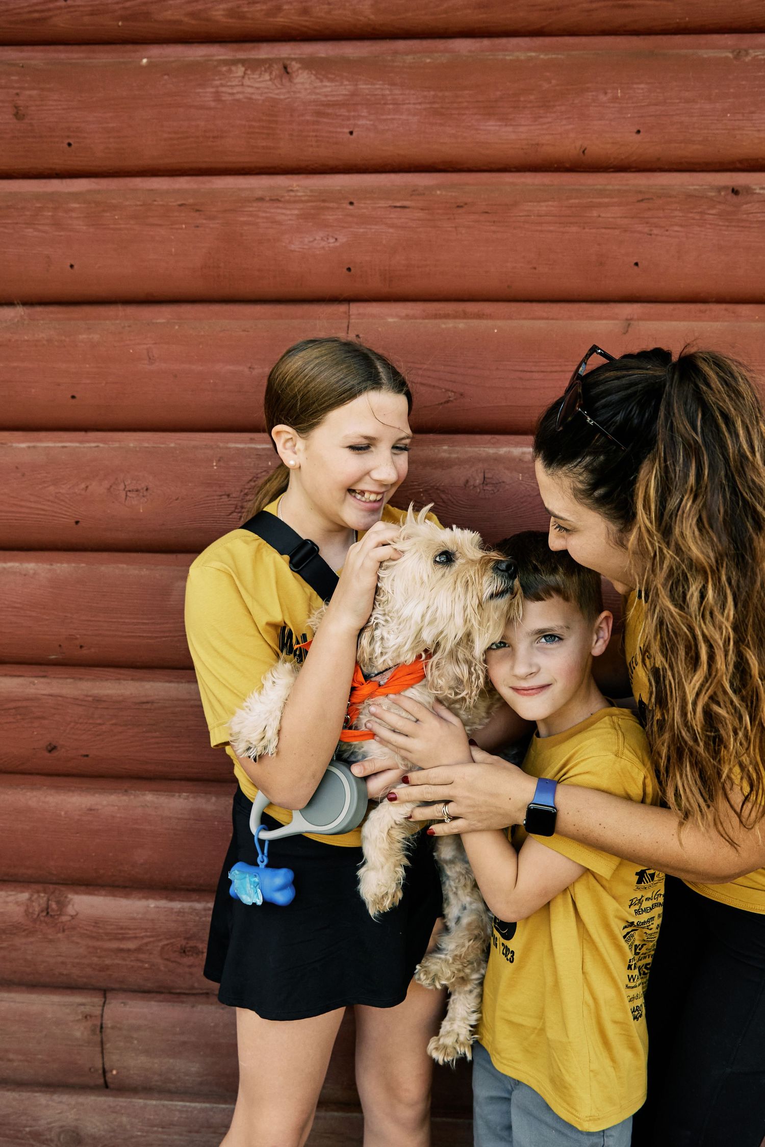 Happy family interaction with small pets against rustic red wall background.