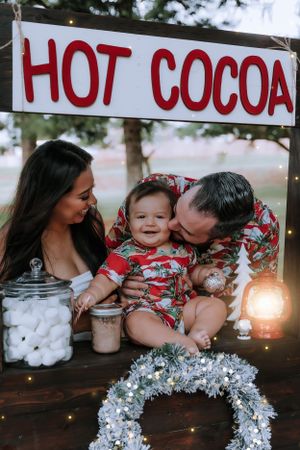 Festive holiday hot cocoa display with marshmallows and silver tinsel decorations on a wooden table.