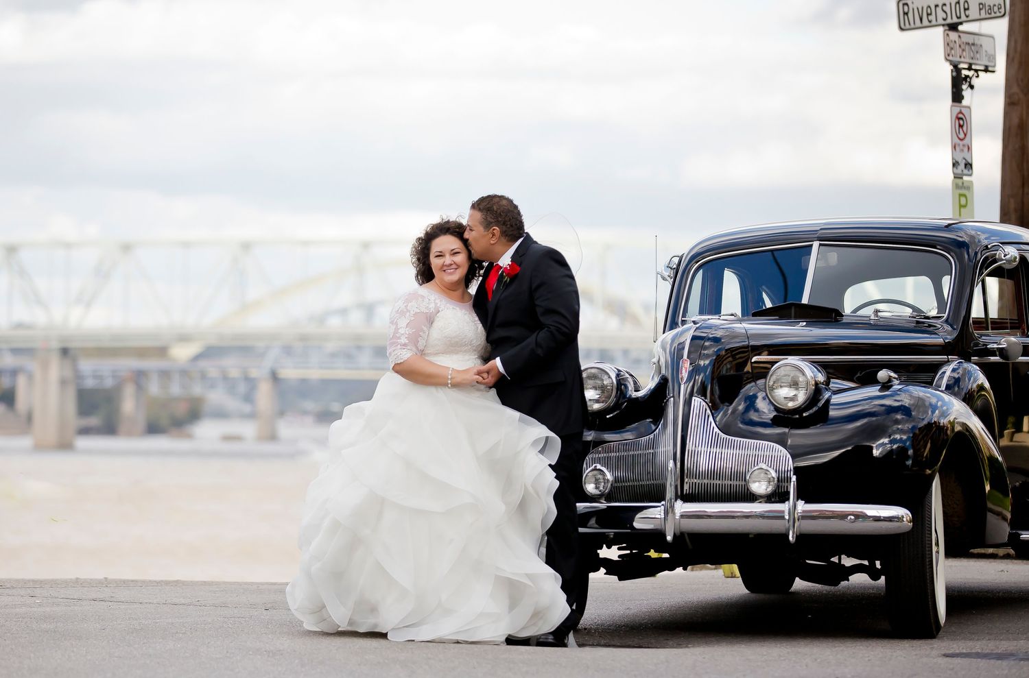Wedding photo series with vintage black car and urban backdrop.