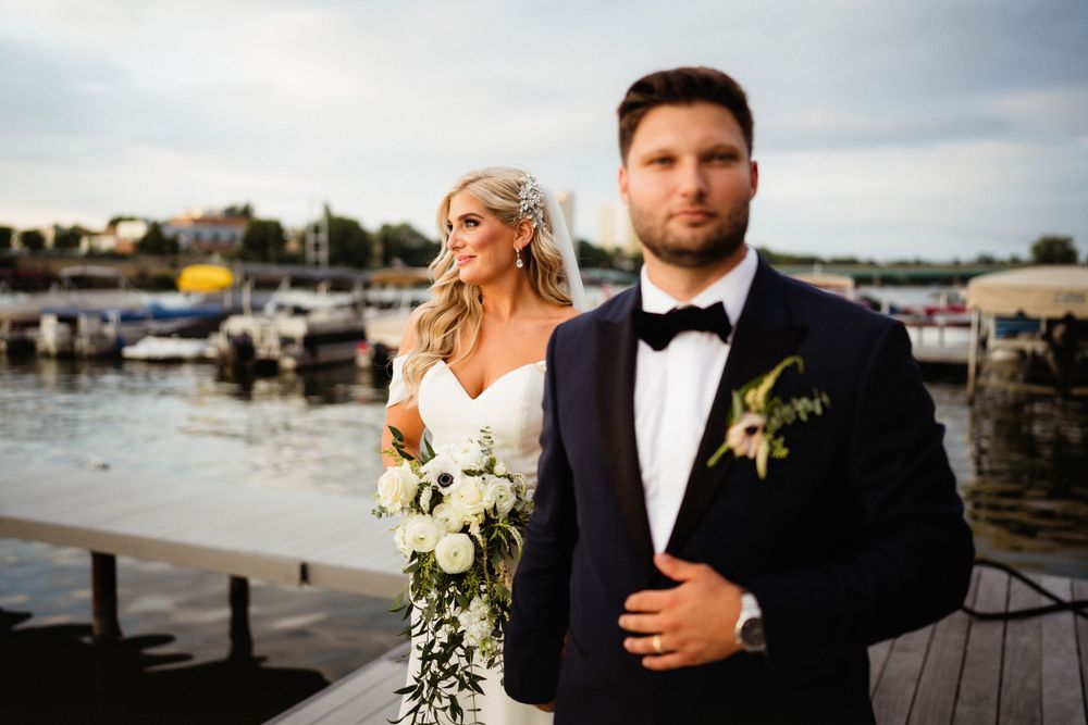 A waterfront wedding portrait with boats and docks in the background.