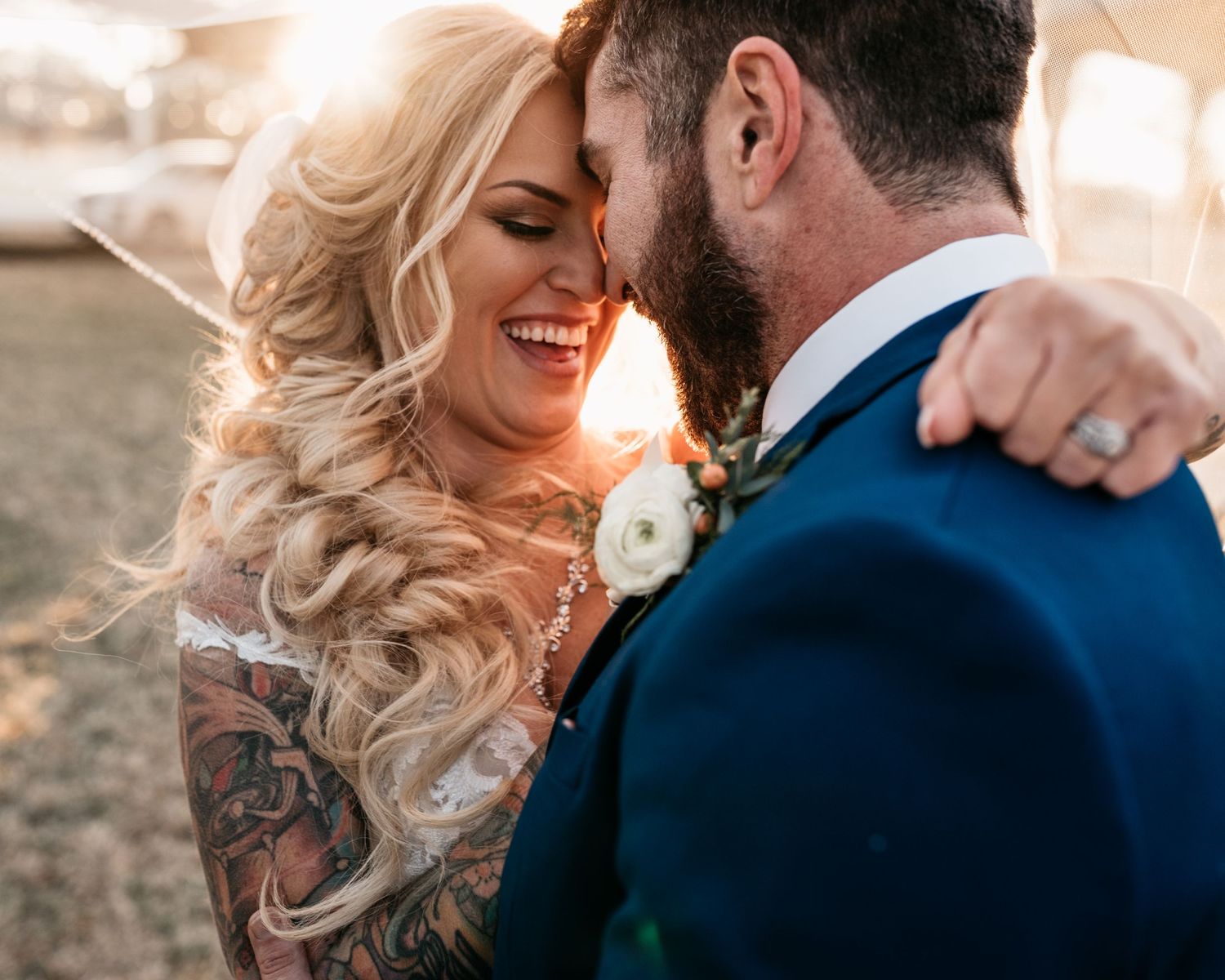 A romantic moment shared between newlyweds at sunset with warm golden lighting.