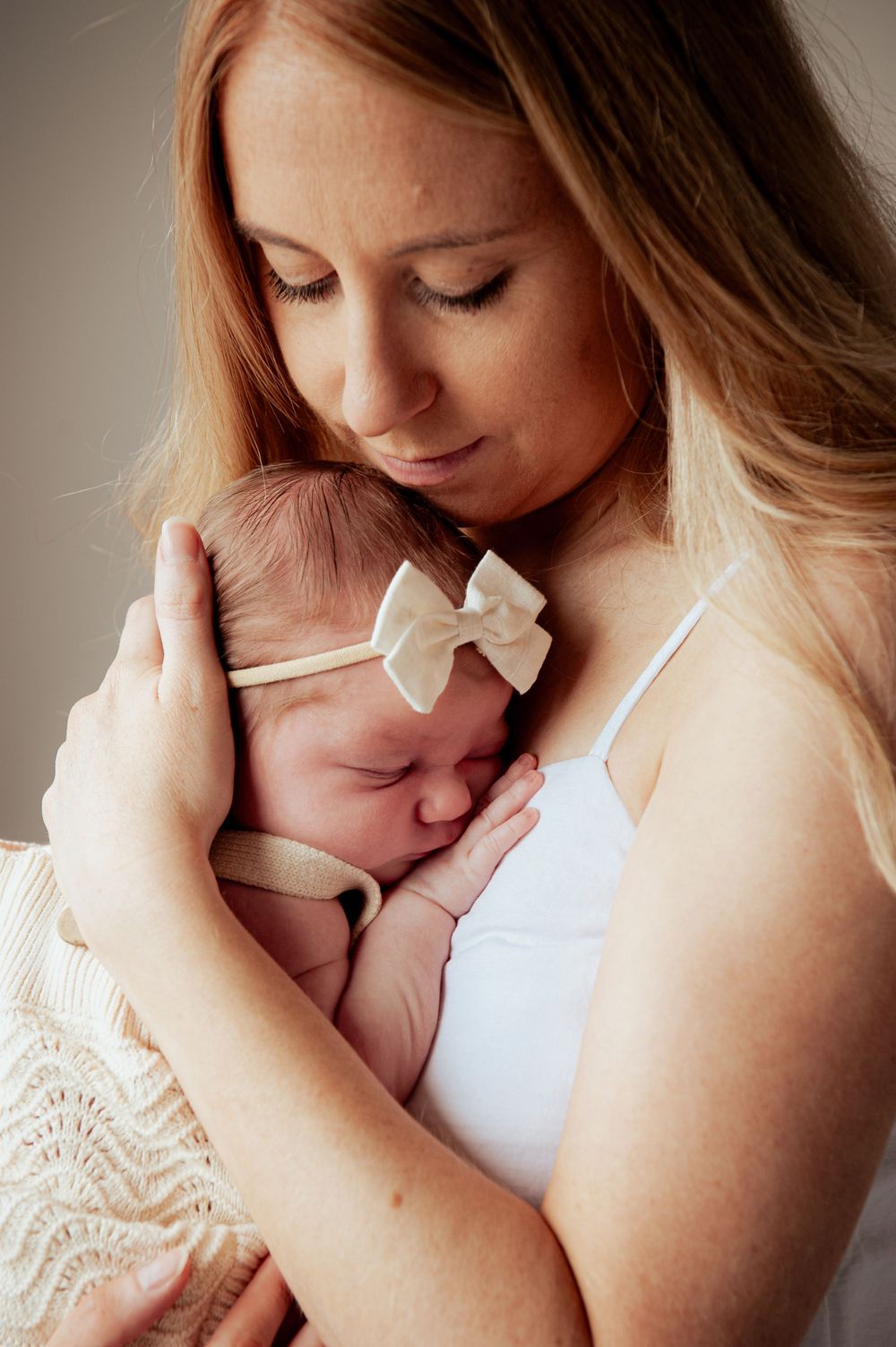 Tender moment of newborn with white bow resting in gentle embrace.
Altona Family Photographer Melbourne