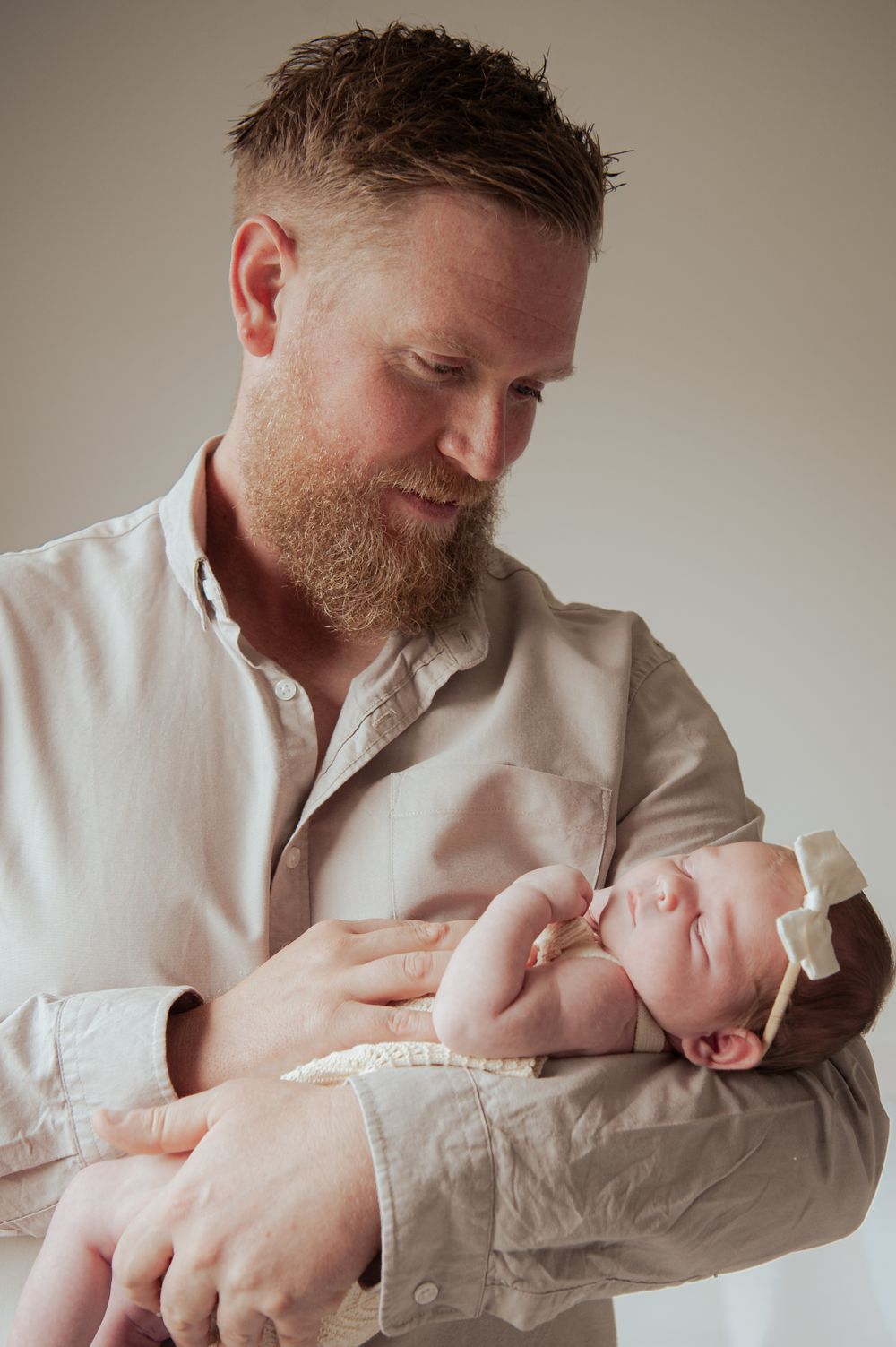 Adult in white shirt holds sleeping infant wrapped in light-colored clothing.
Altona Family Photographer Melbourne