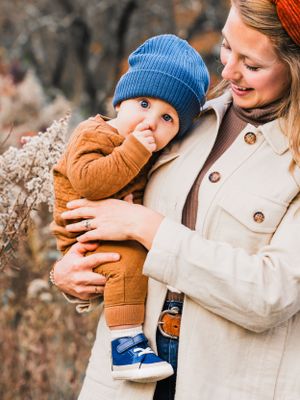 baby in blue hat hugging mama at family photo session