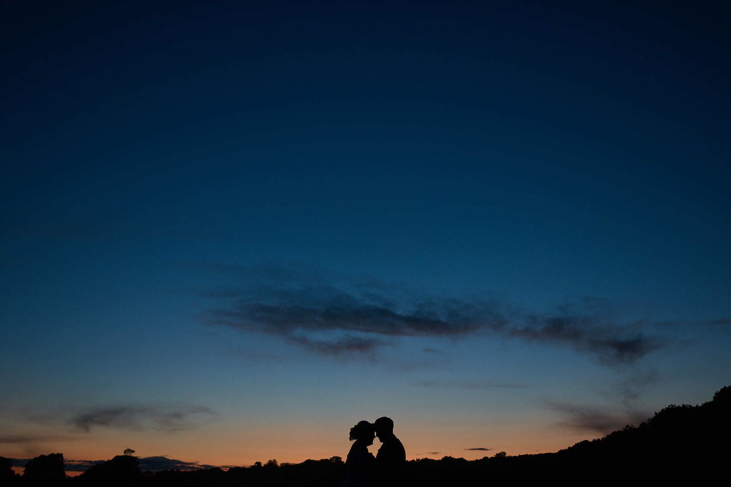 bride and groom have their silhouette portrait taken at blue hour by Faye Amare Photography