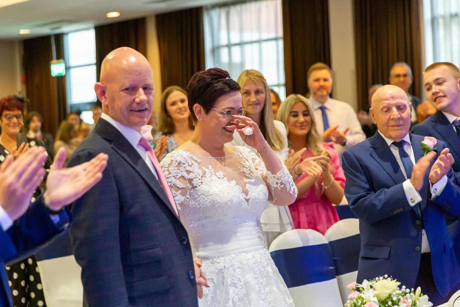 Bride puts her hand to her face smiling during the wedding ceremony at the Crowne Plaza Hotel Liverpool city centre.