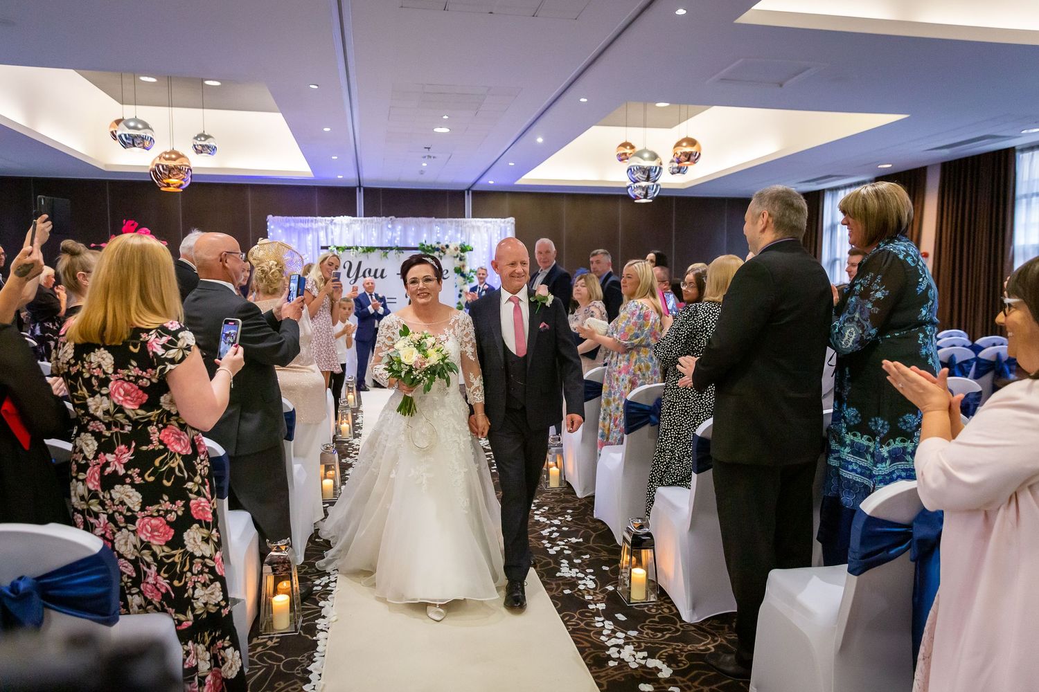 Bride and groom walk up the aisle after the ceremony smiling at the Crowne Plaza Hotel Liverpool City centre