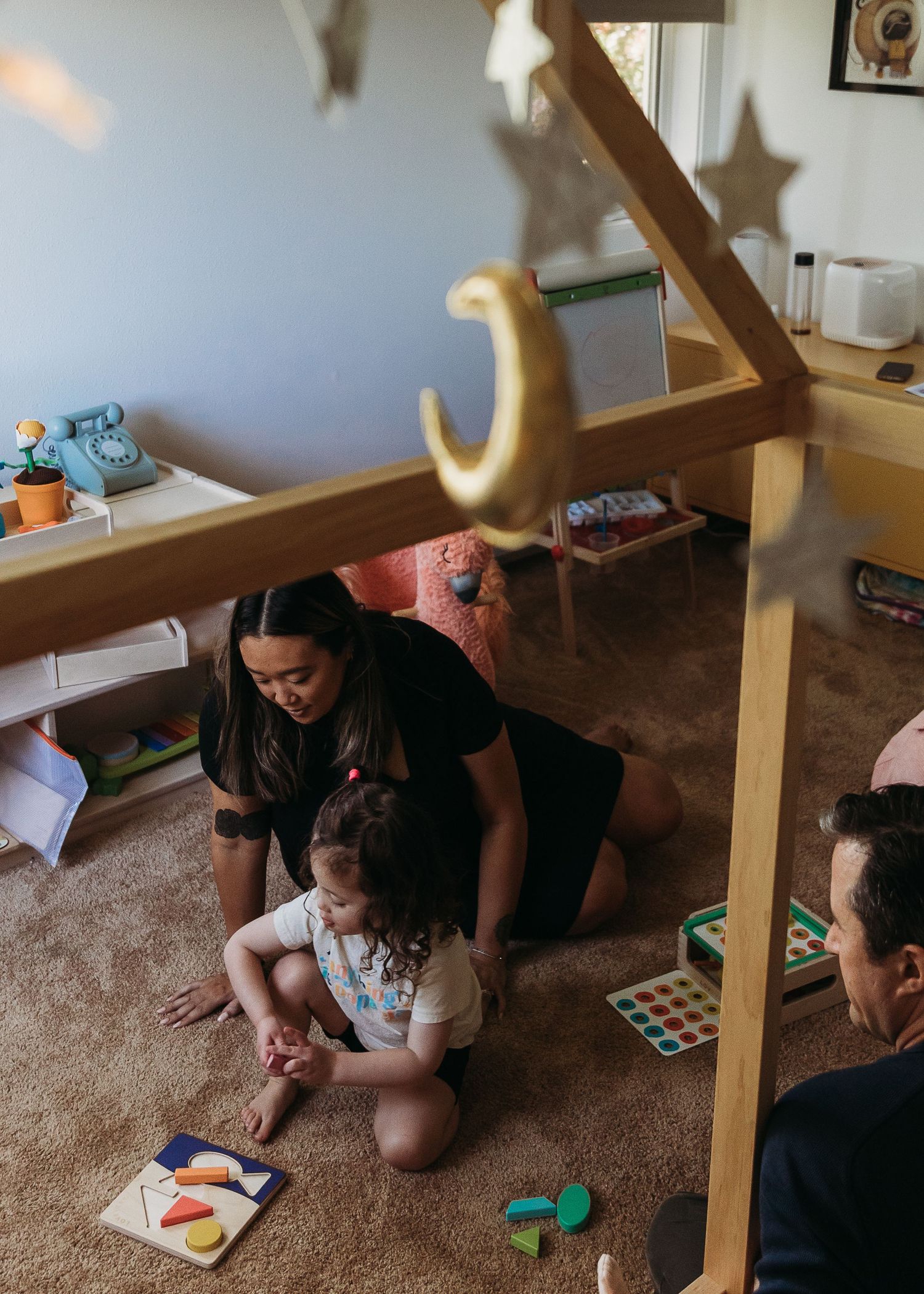 Indoor playtime with toys and games on the carpet under decorative hanging stars.