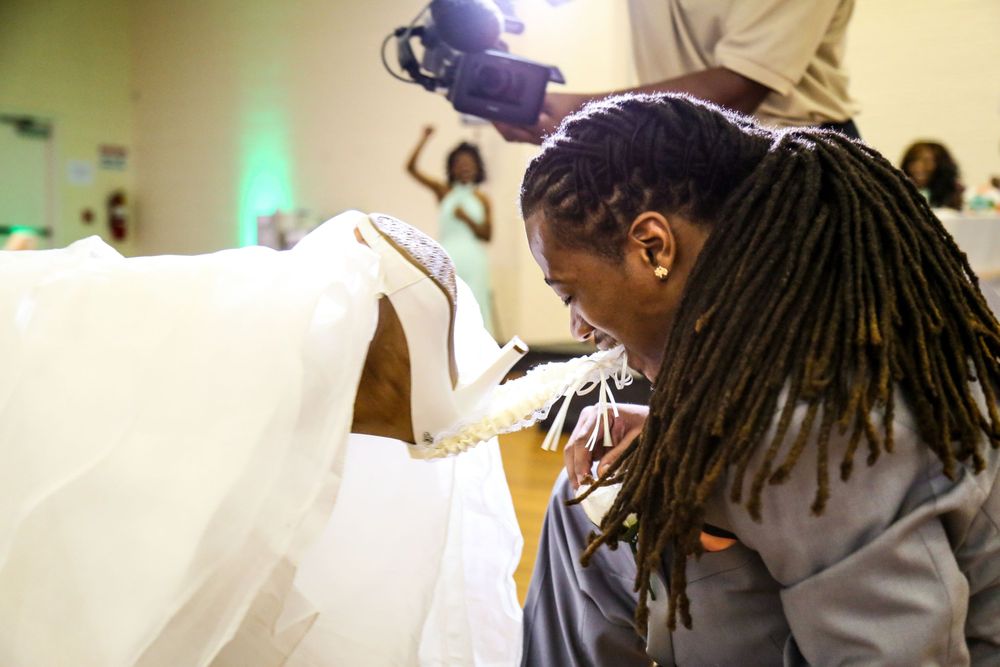 Playful and exciting moment captured as the groom, with a mischievous smile, removes brides garter with teeth