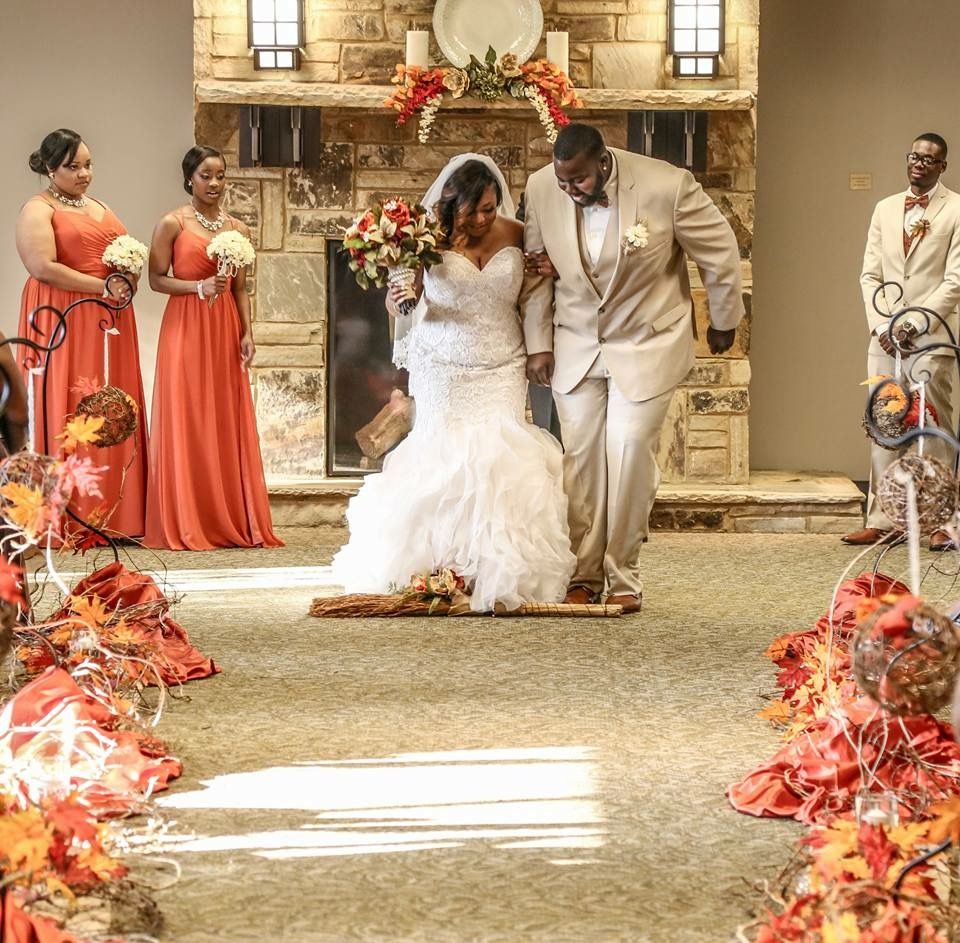 culturally significant moment as the bride and groom joyfully jump over the broom together
