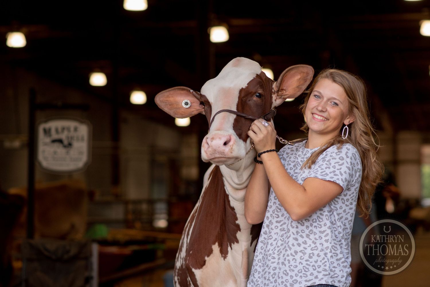 A happy moment between a dairy cow and its handler captured in a barn setting.