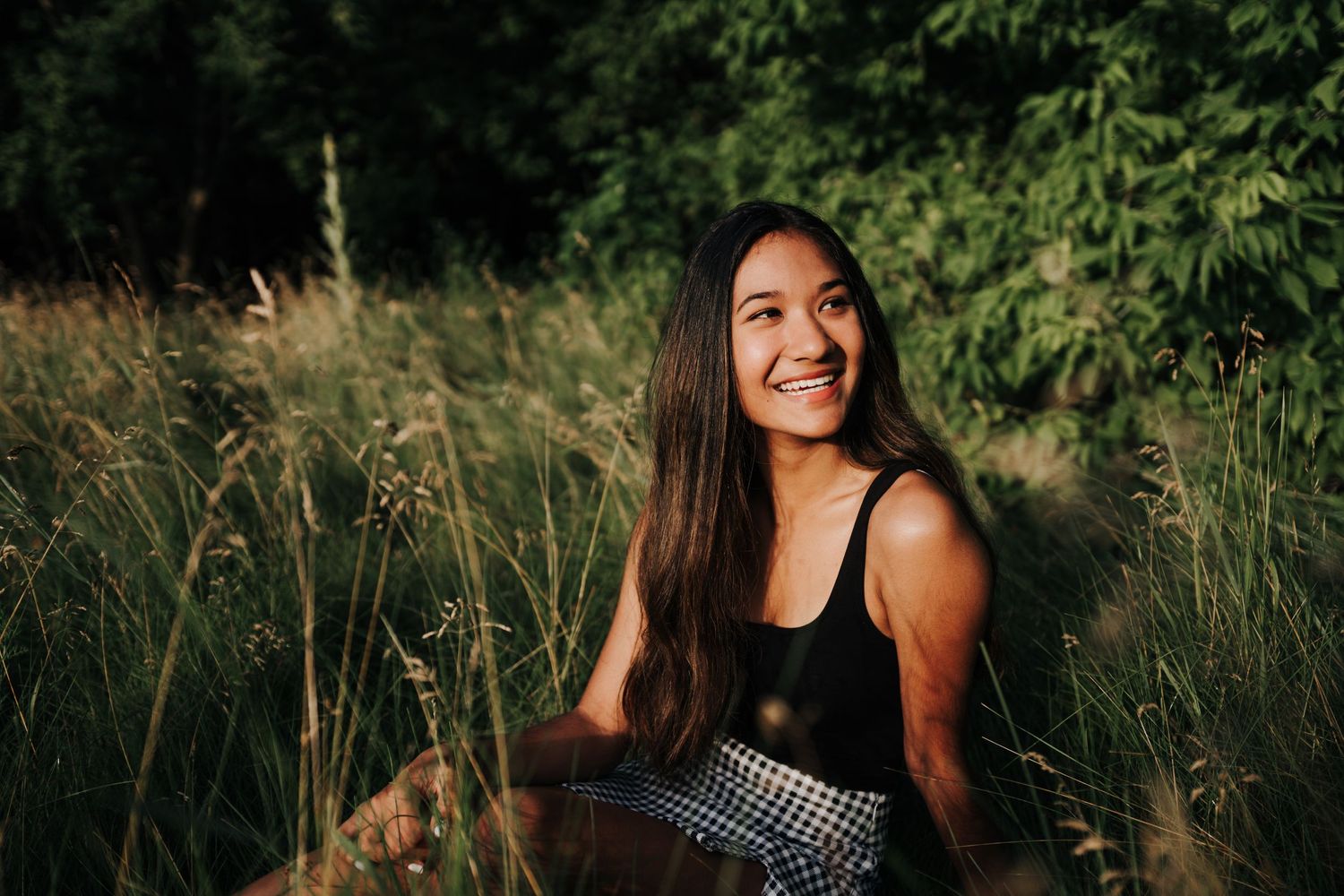 Natural outdoor portraits in a lush green field during golden hour.