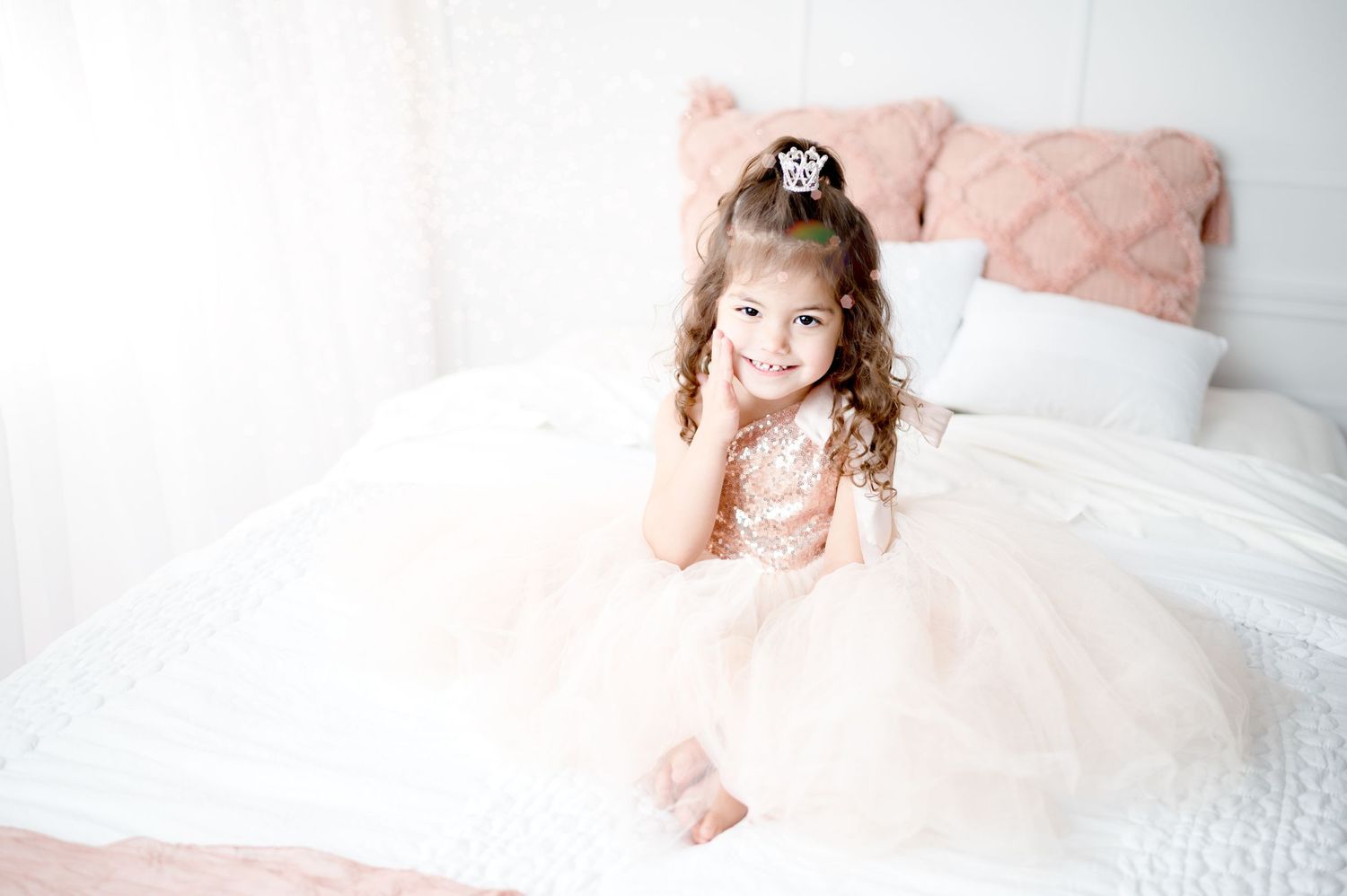 A gentle indoor portrait featuring delicate pink tulle and soft natural lighting.