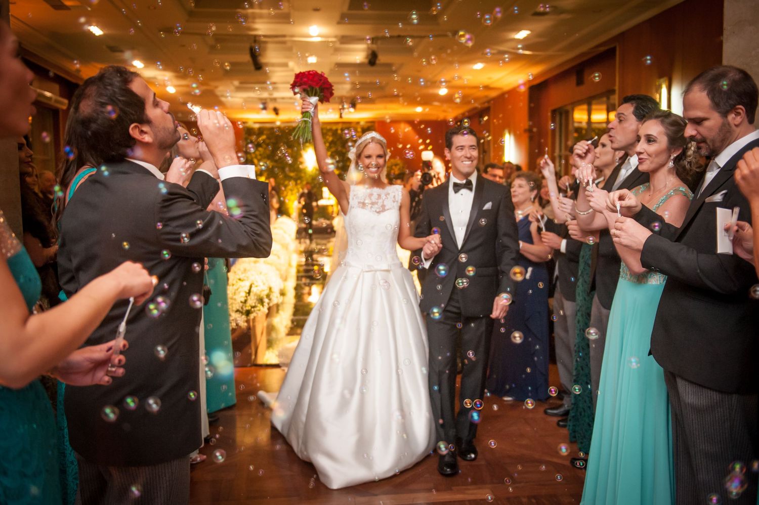 Celebration in warmly lit indoor venue with confetti and chandelier lighting.