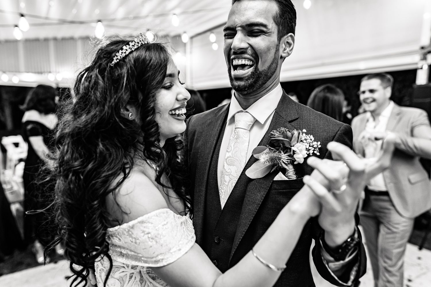 A couple shares a joyful moment while dancing at their wedding celebration.