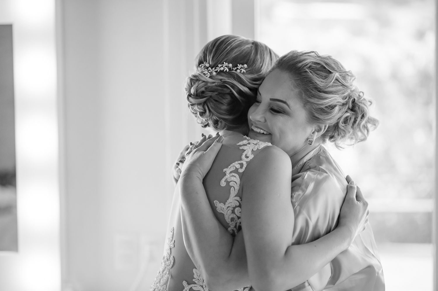 Emotional black and white photograph of two people embracing in formal attire.