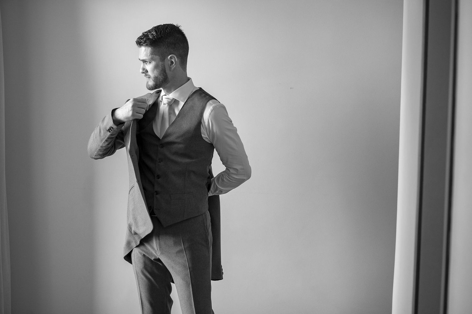 A black and white photo of formal attire preparation in a minimalist setting.