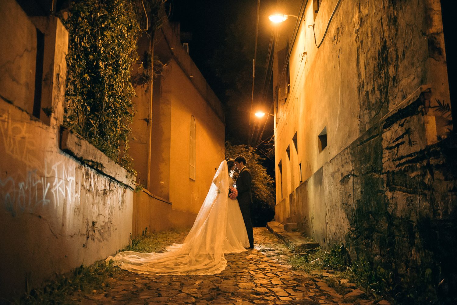A romantic nighttime scene on a cobblestone street with warm lighting.