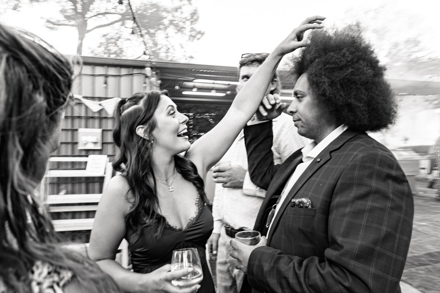 Wedding guests share joyful moment during outdoor celebration.