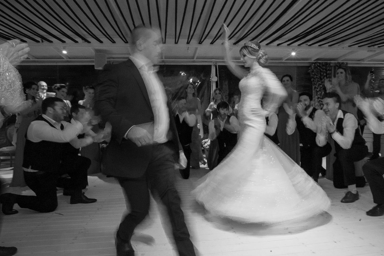 A black and white photo captures dynamic movement during a wedding reception dance.