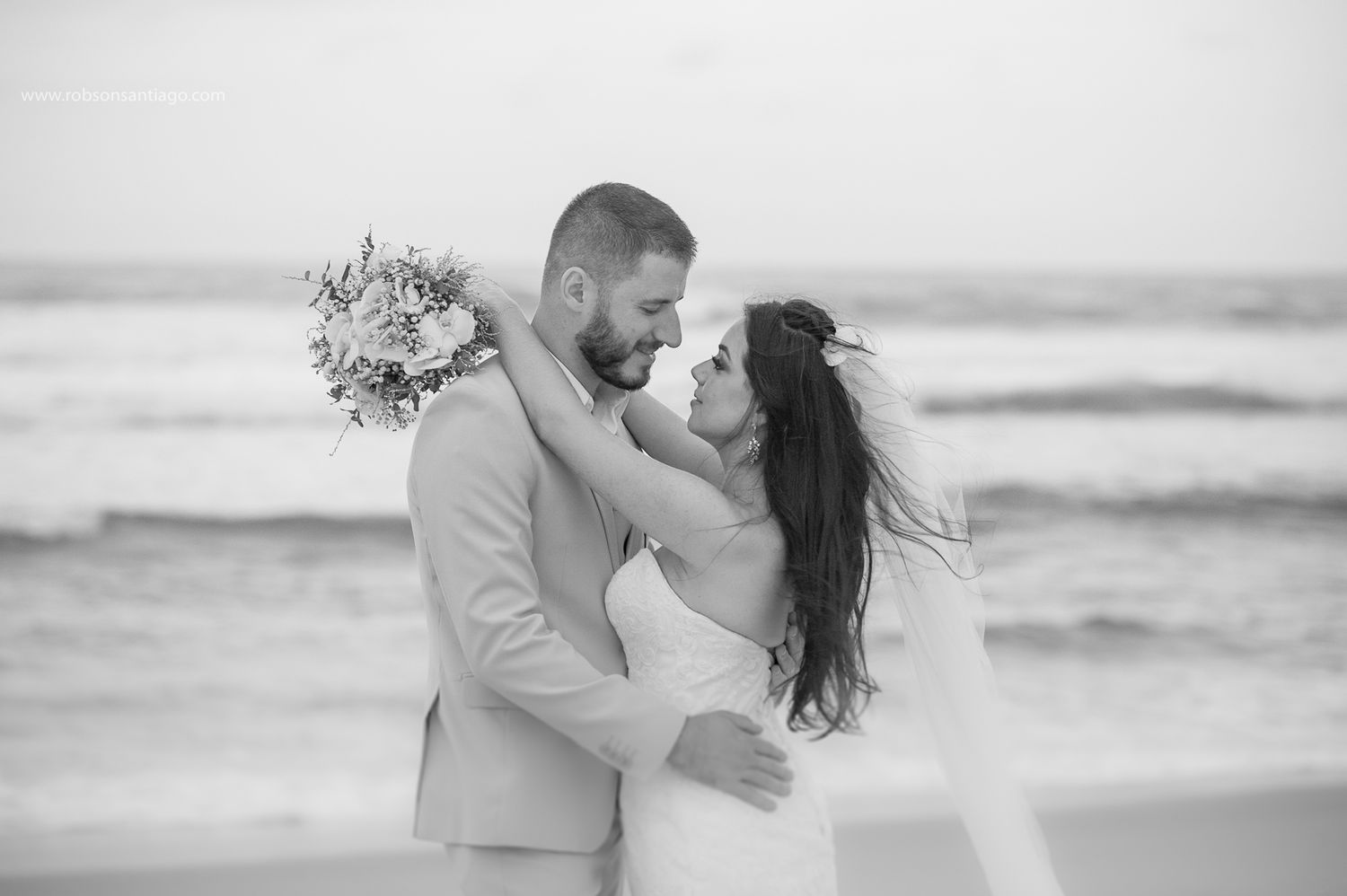 A romantic beach wedding moment captured in black and white.