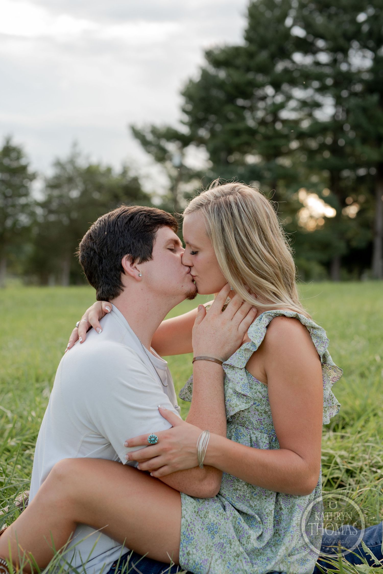 Intimate couple shares romantic kiss in summer field.