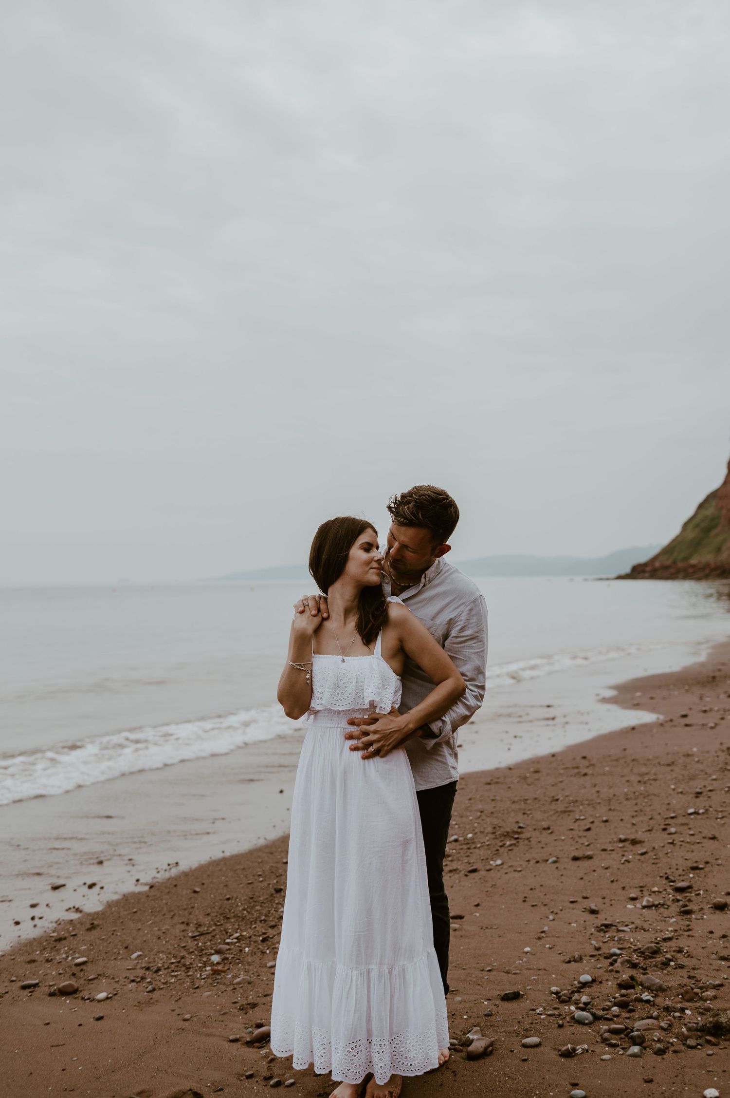 A couples shoot at the beach in Teignmouth. Couple holding hands.