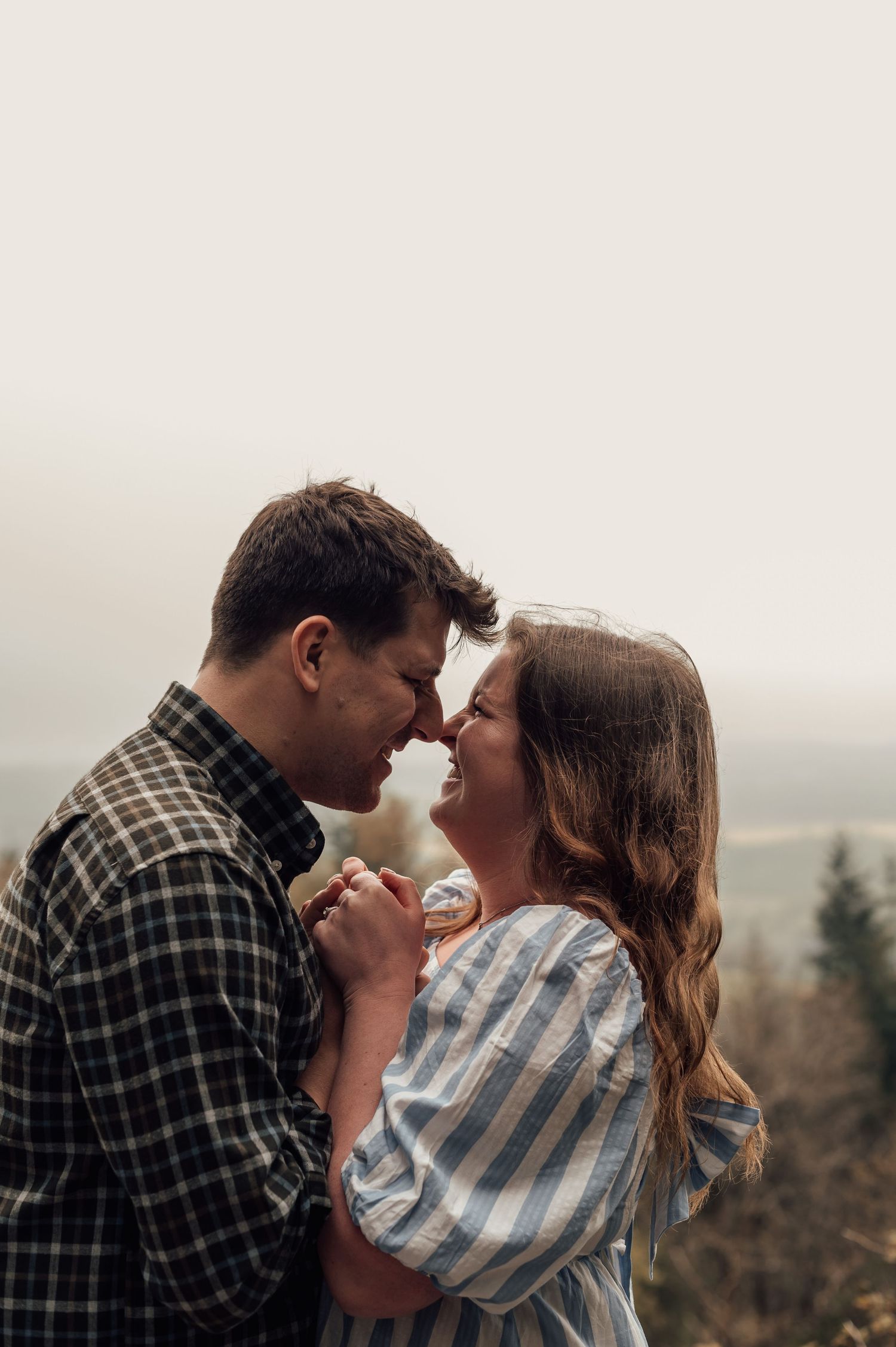 A sweet couple holding hands and standing close in the woods at Haldon Forest for their Couples Photoshoot