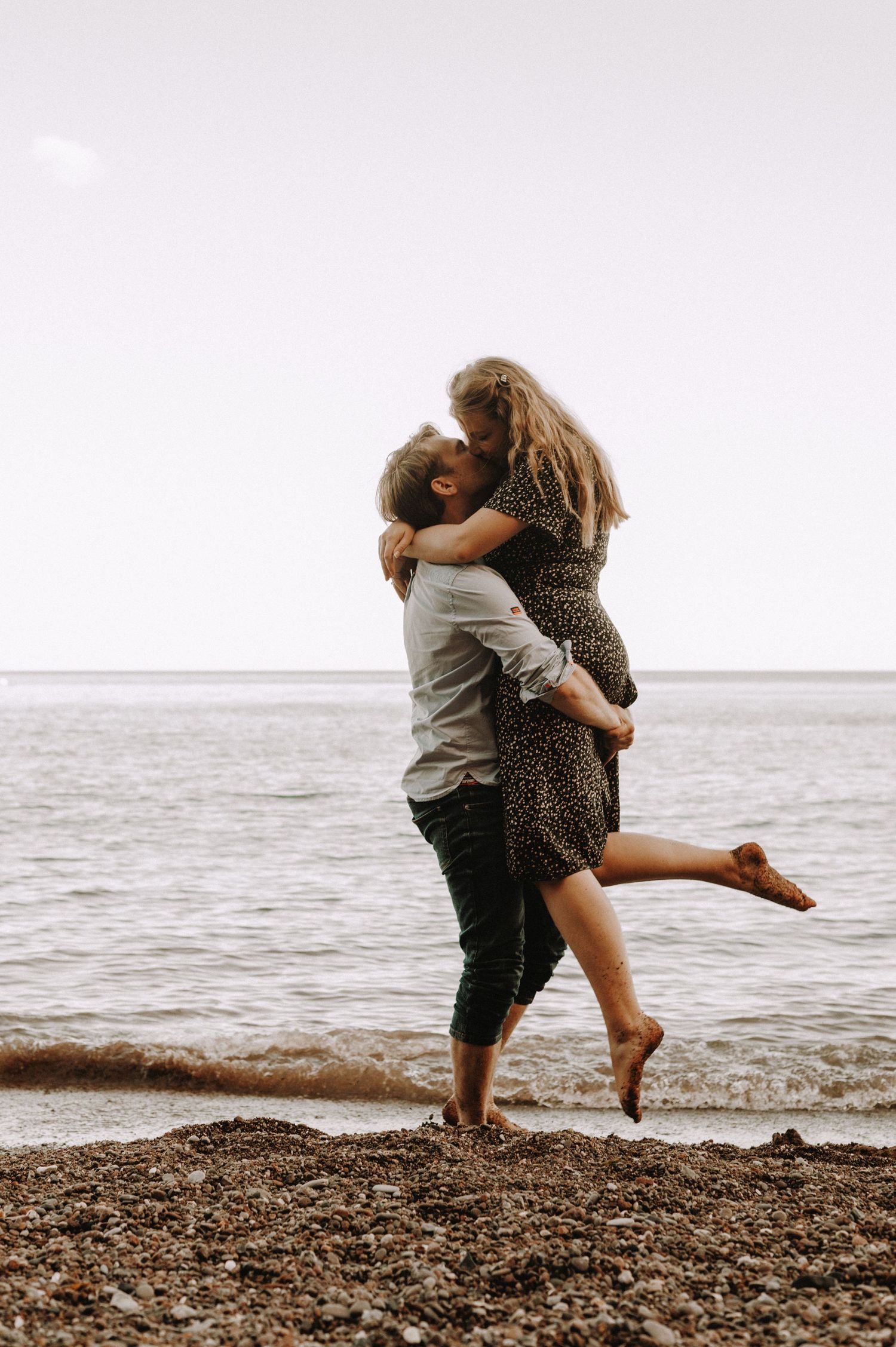 Man picking his Fiance up at the beach for their Engagement Photoshoot at the Beach