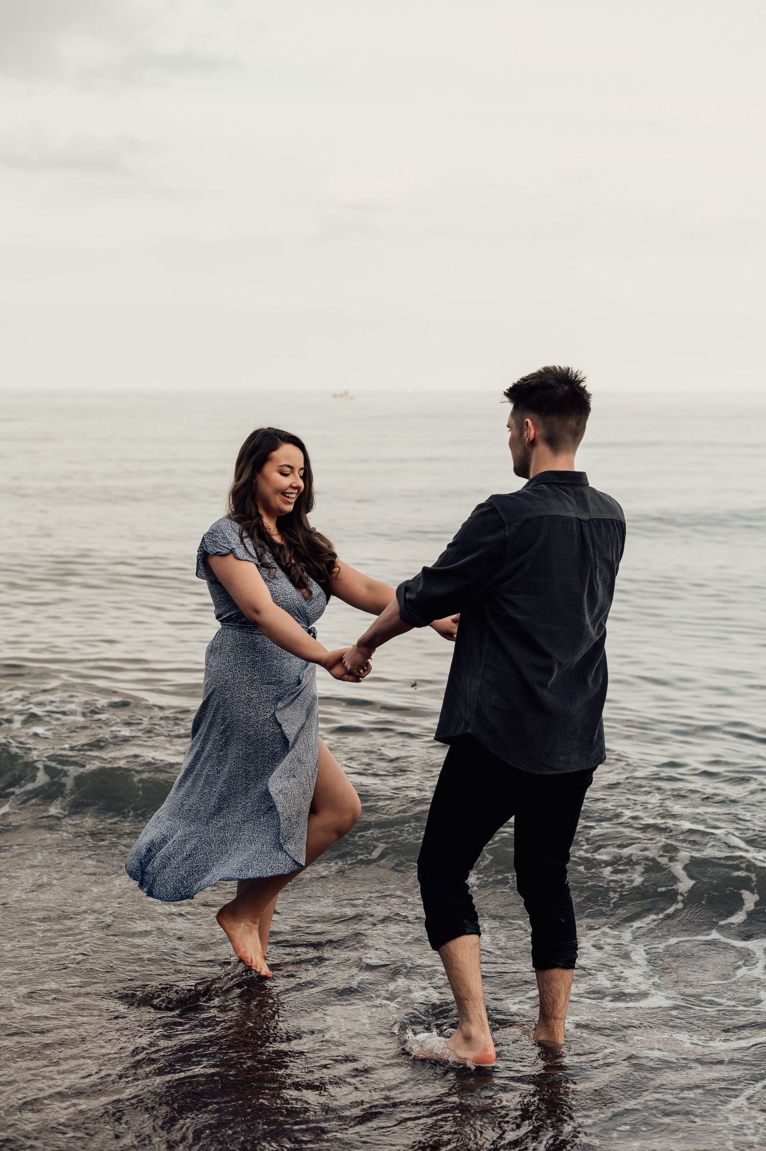 A couple playfully twirling in the sea for their Photoshoot at Shaldon Beach