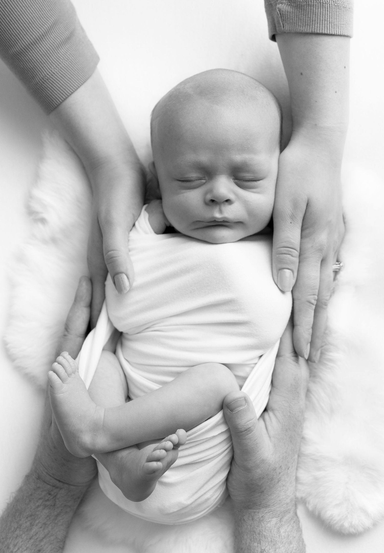 Parents touch baby to show how small he is in newborn photo shoot Victoria BC