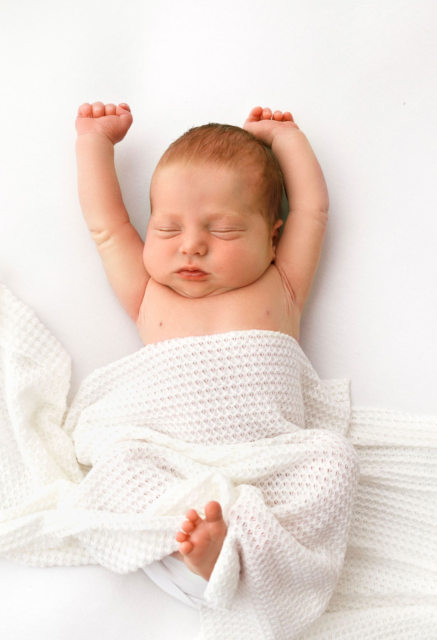 Natural baby pose stretching on the beanbag - timeless white photography