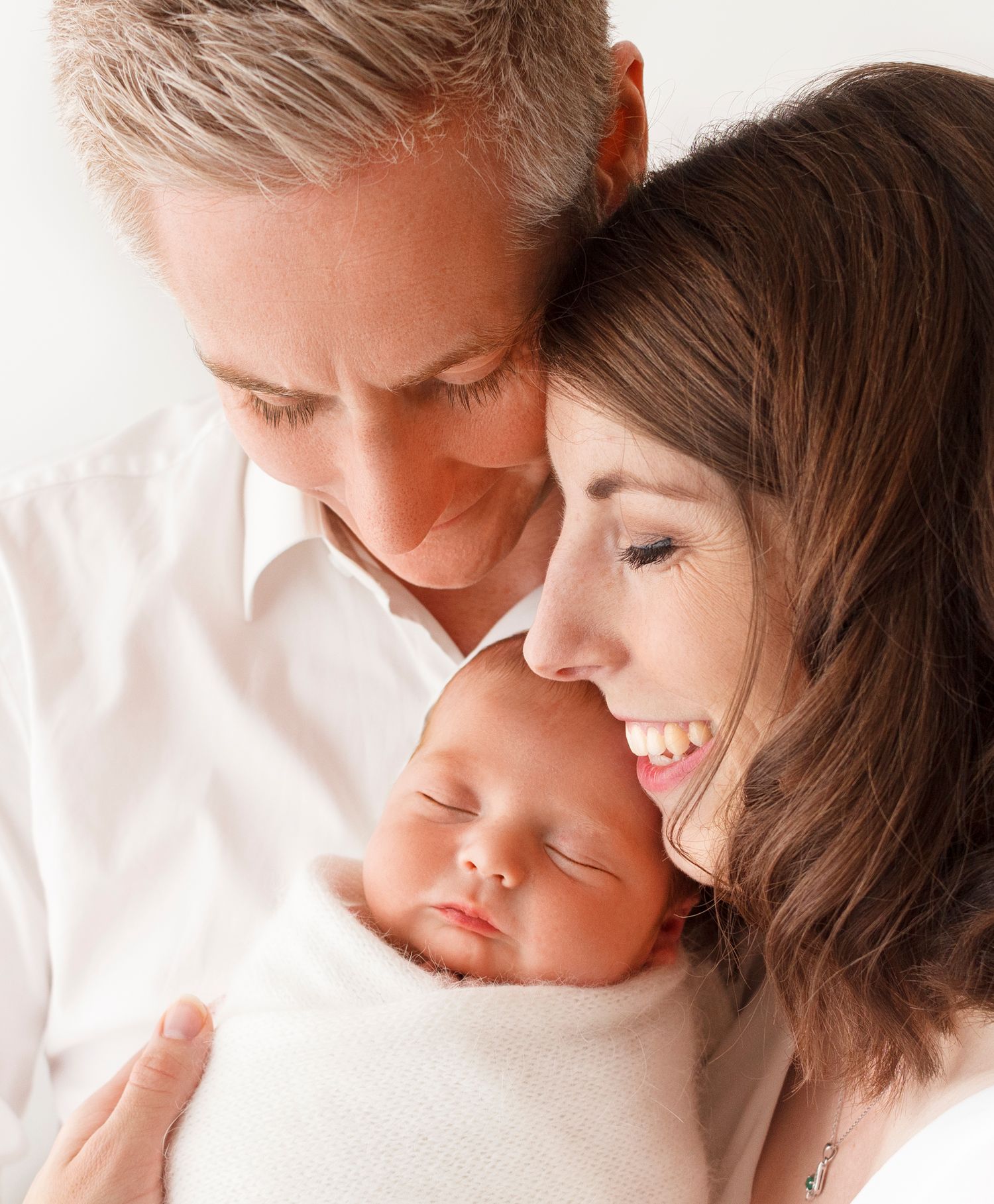 parents hold new baby for family portrait by newborn photographer Tracy McEwan