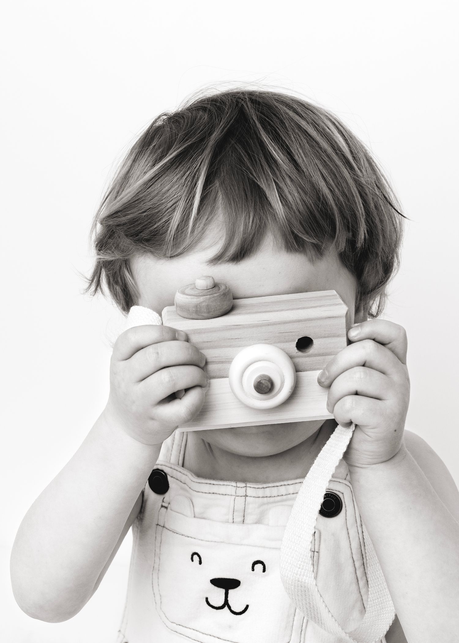 Little boy playing with toy camera at family photoshoot in Victoria BC