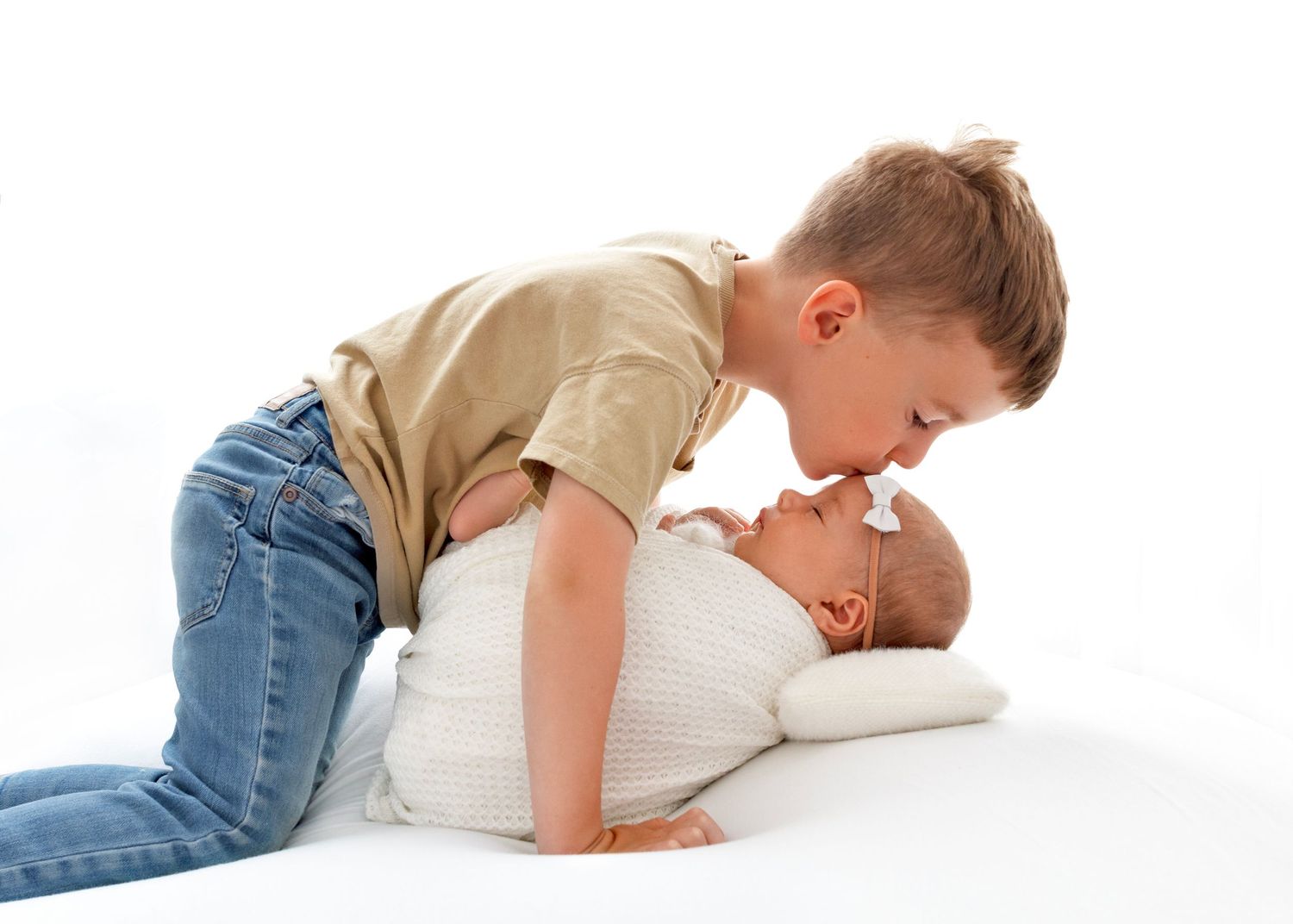 Big brother kissing new baby sister in photo studio Victoria BC