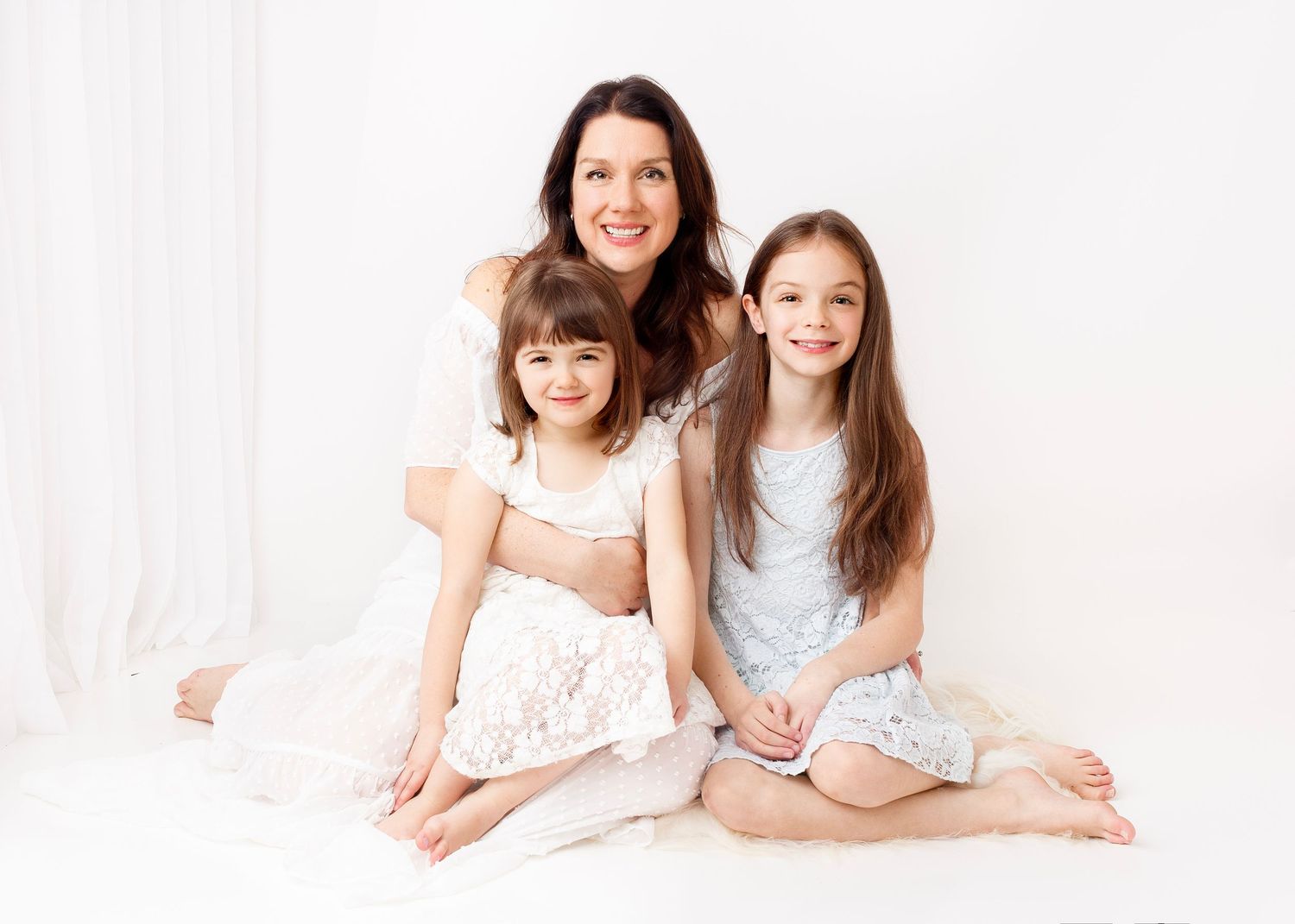 Natural family photography: Mother sitting with her two girls